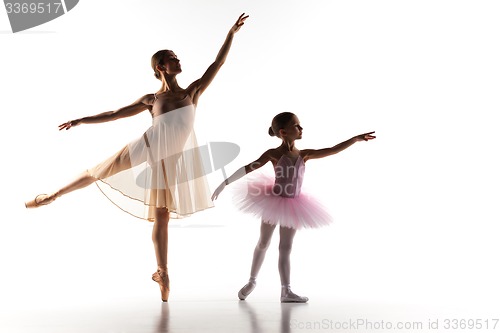 Image of The little ballerina dancing with personal ballet teacher in dance studio
