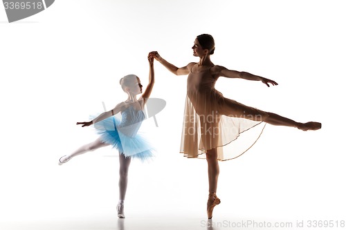 Image of The little ballerina dancing with personal ballet teacher in dance studio