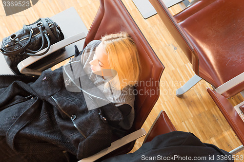 Image of Tired female traveler waiting for departure.