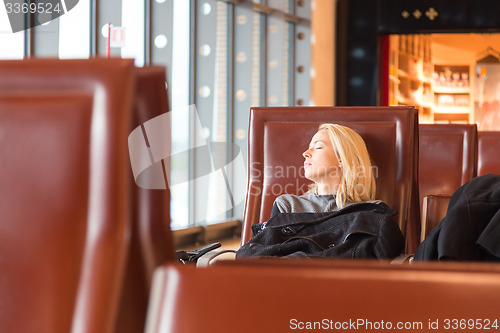 Image of Tired female traveler waiting for departure.