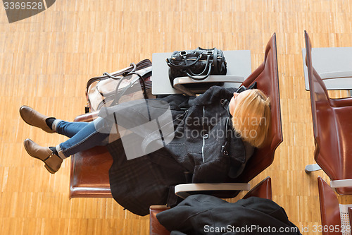 Image of Tired female traveler waiting for departure.