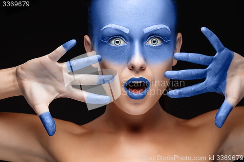 Image of Portrait of a woman who is posing covered with blue paint