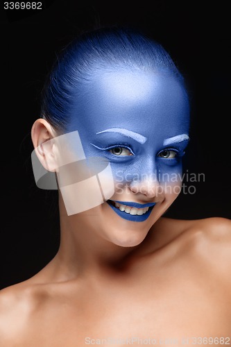 Image of Portrait of a woman who is posing covered with blue paint