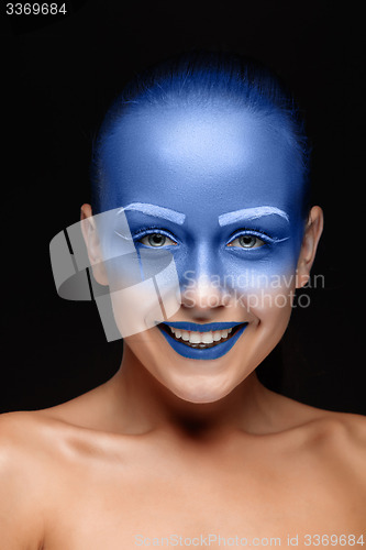 Image of Portrait of a woman who is posing covered with blue paint