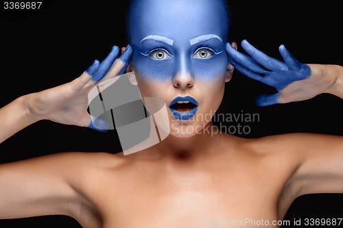 Image of Portrait of a woman who is posing covered with blue paint