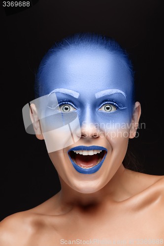 Image of Portrait of a woman who is posing covered with blue paint