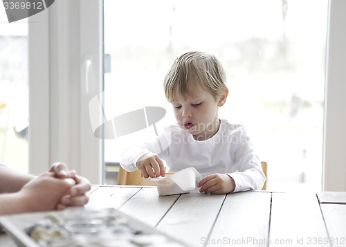 Image of Boy eating yogurt at the table