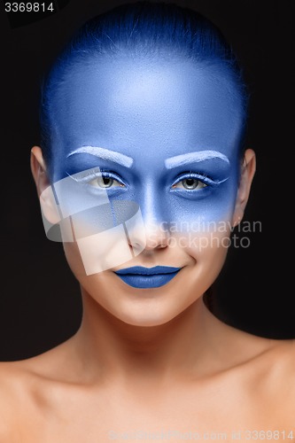 Image of Portrait of a woman who is posing covered with blue paint