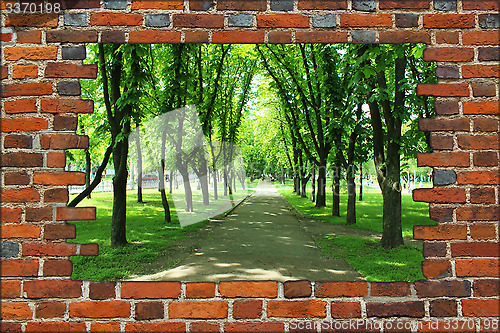 Image of broken brick wall and view to Summer park