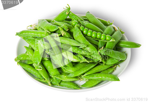 Image of Big pile opening and closing pea pods on white plate