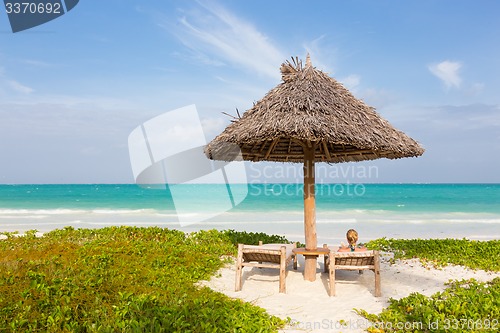 Image of Woman sunbathing on tropical beach.