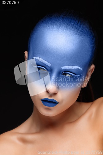 Image of Portrait of a woman who is posing covered with blue paint