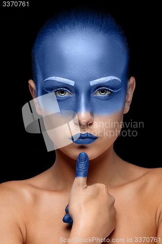 Image of Portrait of a woman who is posing covered with blue paint