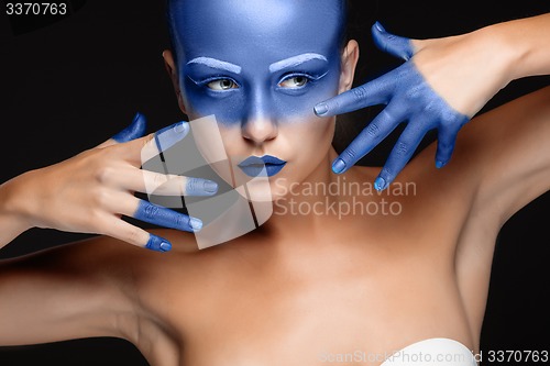 Image of Portrait of a woman who is posing covered with blue paint