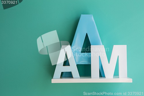 Image of Letters A and M on a white shelf.