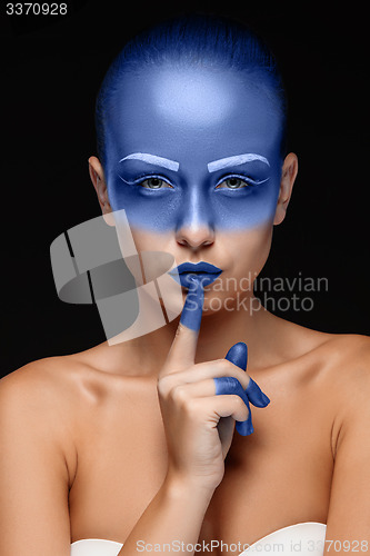 Image of Portrait of a woman who is posing covered with blue paint