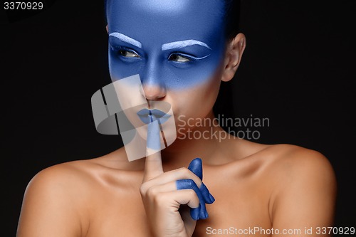 Image of Portrait of a woman who is posing covered with blue paint