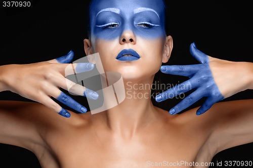 Image of Portrait of a woman who is posing covered with blue paint