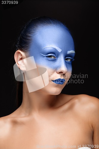 Image of Portrait of a woman who is posing covered with blue paint