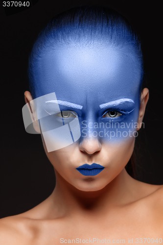 Image of Portrait of a woman who is posing covered with blue paint