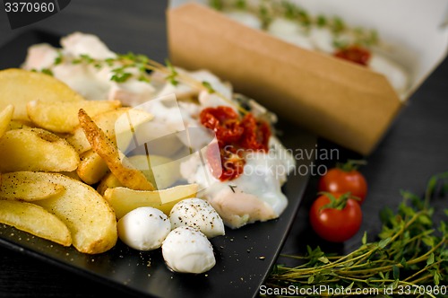 Image of Delicious portion of rustic potatoes fillet with aromatic herbs