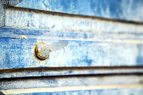 Image of stripped   in   blue wood door and rusty nail