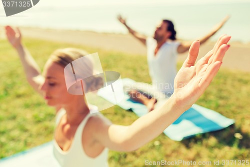 Image of close up of couple making yoga exercises outdoors