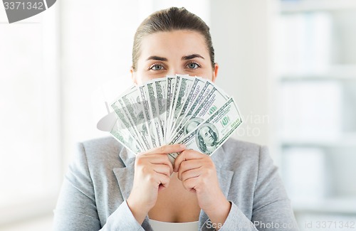 Image of woman hiding her face behind us dollar money fan