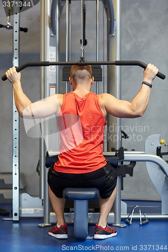 Image of man flexing muscles on cable machine gym