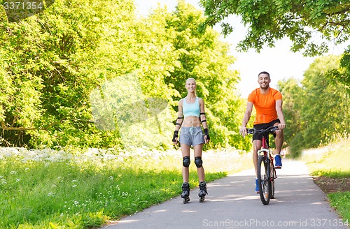 Image of happy couple with rollerblades and bicycle riding