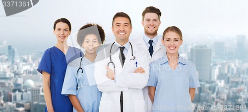 Image of group of happy doctors over blue background