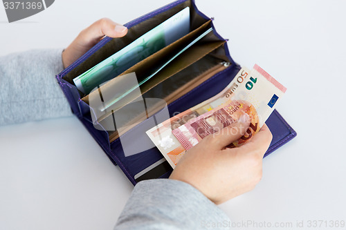 Image of close up of woman hands with wallet and euro money