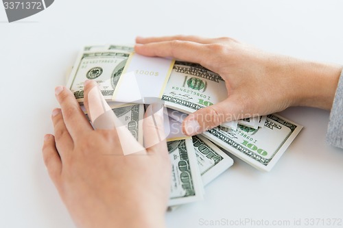 Image of close up of woman hands counting us dollar money