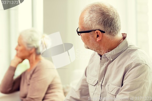 Image of senior couple sitting on sofa at home