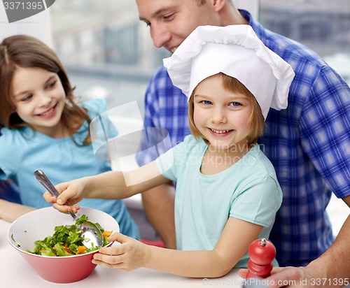 Image of happy family with two kids cooking at home