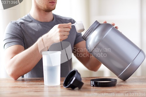 Image of close up of man with protein shake bottle and jar