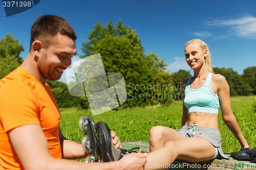 Image of happy couple with rollerblades outdoors