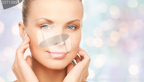 Image of beautiful young woman touching her face