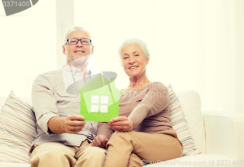 Image of happy senior couple hugging on sofa at home