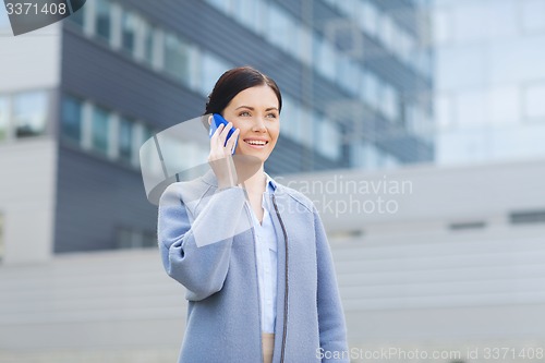 Image of young smiling businesswoman calling on smartphone