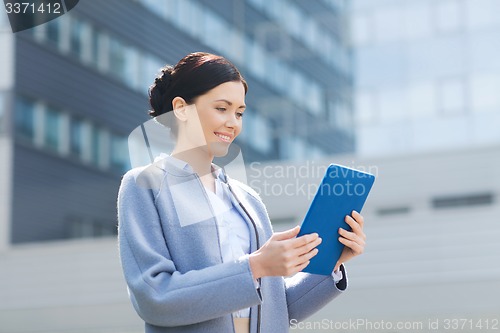 Image of smiling business woman with tablet pc in city