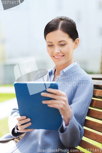 Image of smiling business woman with tablet pc in city