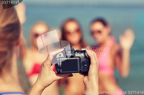 Image of close up of smiling women photographing on beach