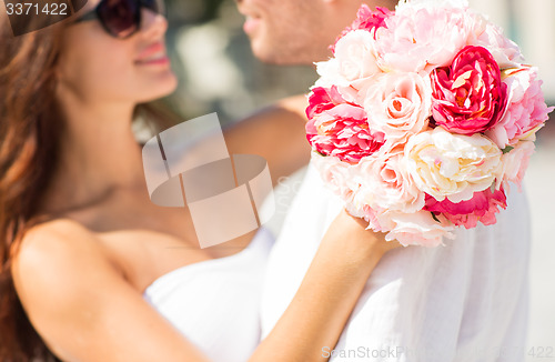 Image of close up of couple with bunch flowers in city