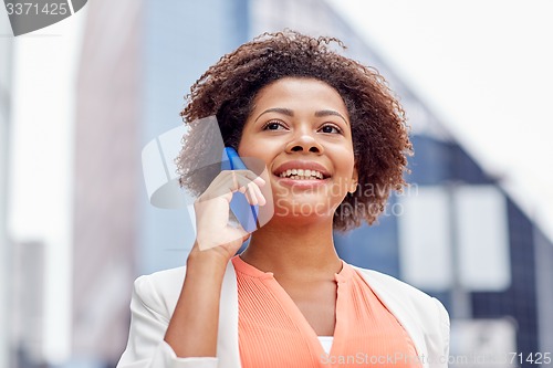 Image of happy african businesswoman calling on smartphone