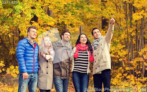 Image of group of smiling men and women in autumn park