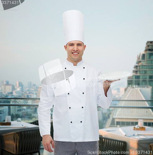 Image of happy male chef cook showing empty plate