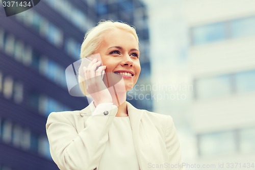 Image of smiling businesswoman with smartphone outdoors