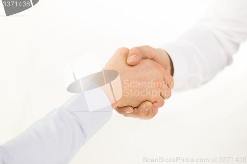 Image of close up of hands making handshake in office