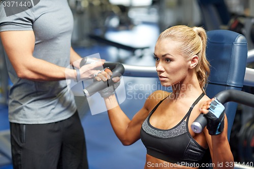 Image of man and woman flexing muscles on gym machine